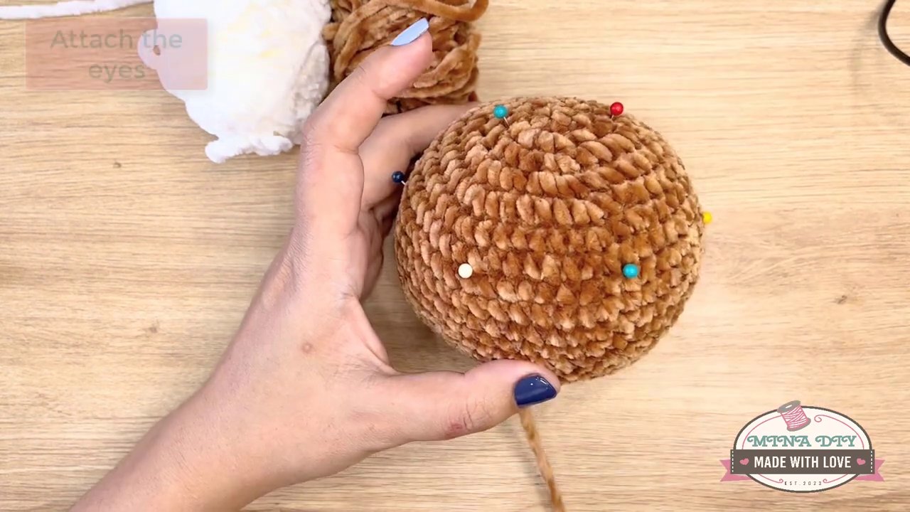Bringing Your Amigurumi to Life: A Step-by-Step Guide to Embroidering Eyes and Noses 3 The needle and white yarn are shown in detail, stitching a neat, crescent-shaped highlight around the edge of a black safety eye.