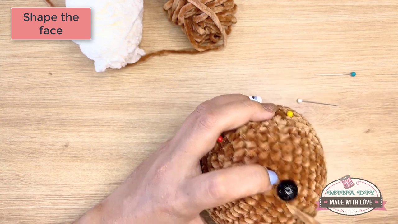 Bringing Your Amigurumi to Life: A Step-by-Step Guide to Embroidering Eyes and Noses 6 The finished face is held in a hand, showcasing the complete, expressive features of the crocheted animal.