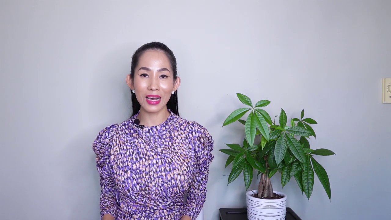 Chuyên gia tâm linh với phong cách thanh lịch, đứng trước bối cảnh trang nhã, bắt đầu chia sẻ về chủ đề đặc biệt.