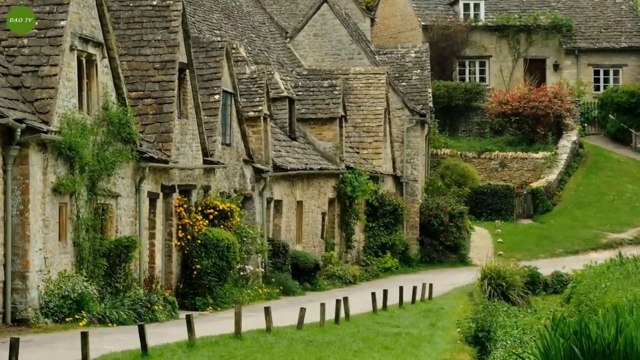 Toàn cảnh ngôi làng Bibury với những ngôi nhà bằng đá nâu vàng bên dòng sông hiền hòa.